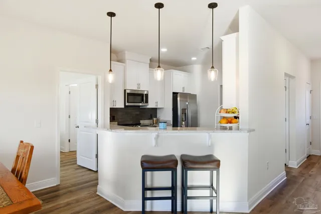 a dining room with furniture a chandelier and wooden floor