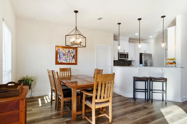 a living room with furniture kitchen view and a wooden floor
