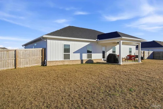 a front view of house with yard and trees in the background