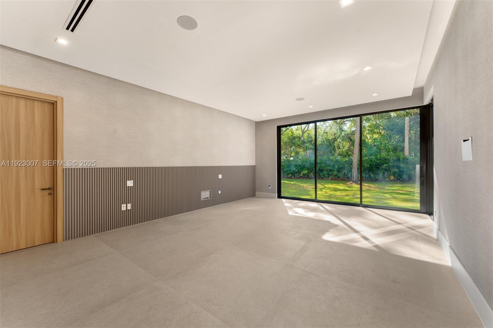 6840 Southwest 92nd Street Pinecrest, FL 33156 - Photo 25 of 42 a view of an empty room with a large window and kitchen view