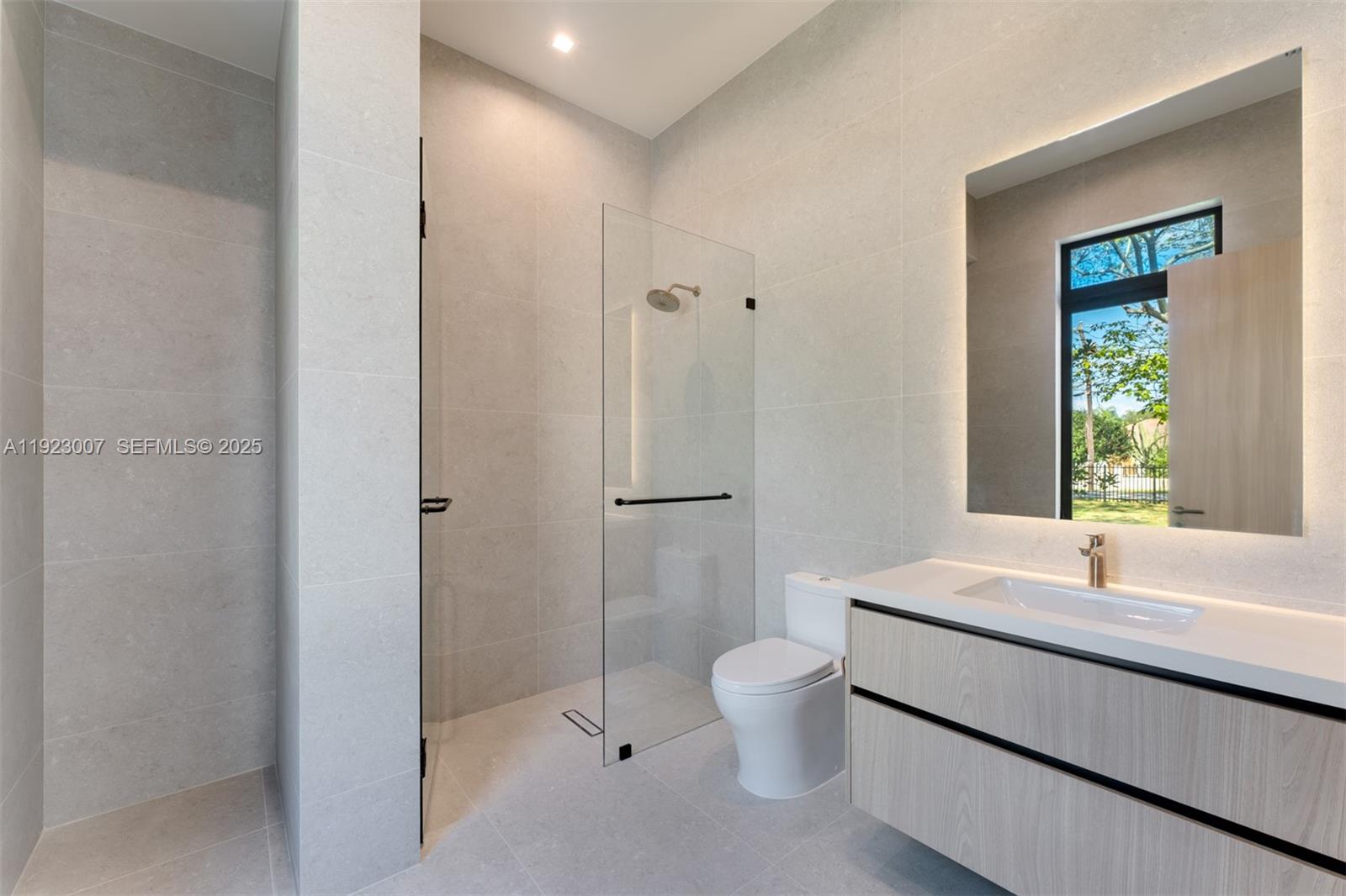 6840 Southwest 92nd Street Pinecrest, FL 33156 - Photo 28 of 42 a bathroom with a sink and a large mirror