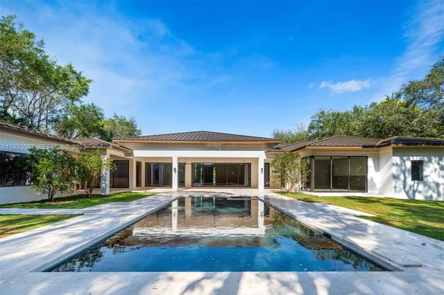 a view of a house with swimming pool and a yard