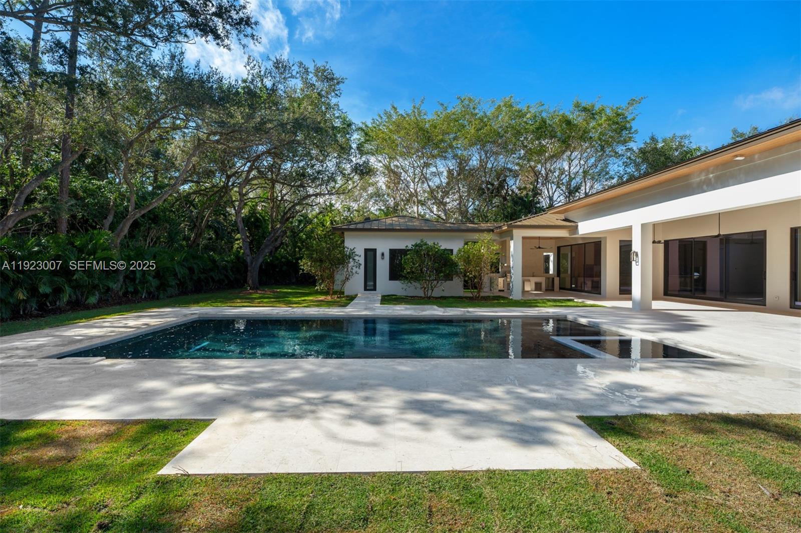 6840 Southwest 92nd Street Pinecrest, FL 33156 - Photo 34 of 42 a view of a house with swimming pool and a yard