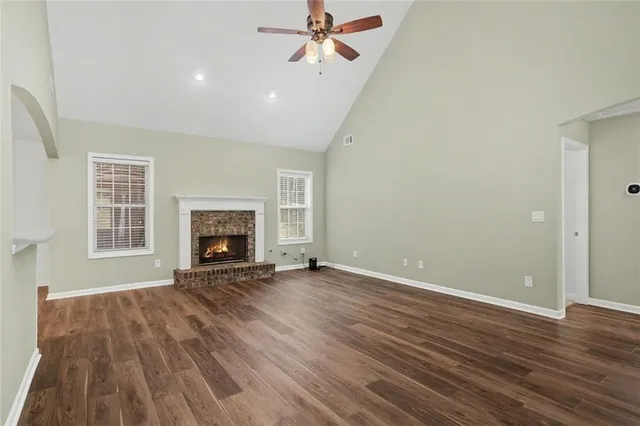 an empty room with windows and fireplace