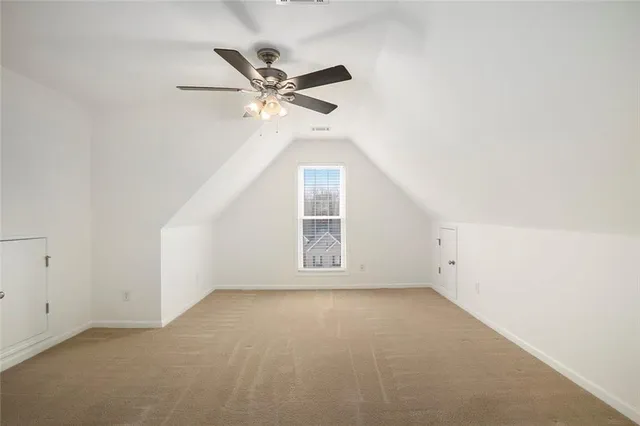 an empty room with a window and a ceiling fan