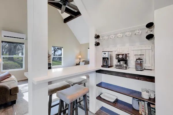 a kitchen with stainless steel appliances kitchen island granite countertop a table chairs sink and cabinets