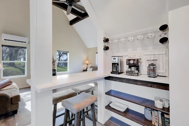 a kitchen with stainless steel appliances kitchen island granite countertop a table chairs sink and cabinets