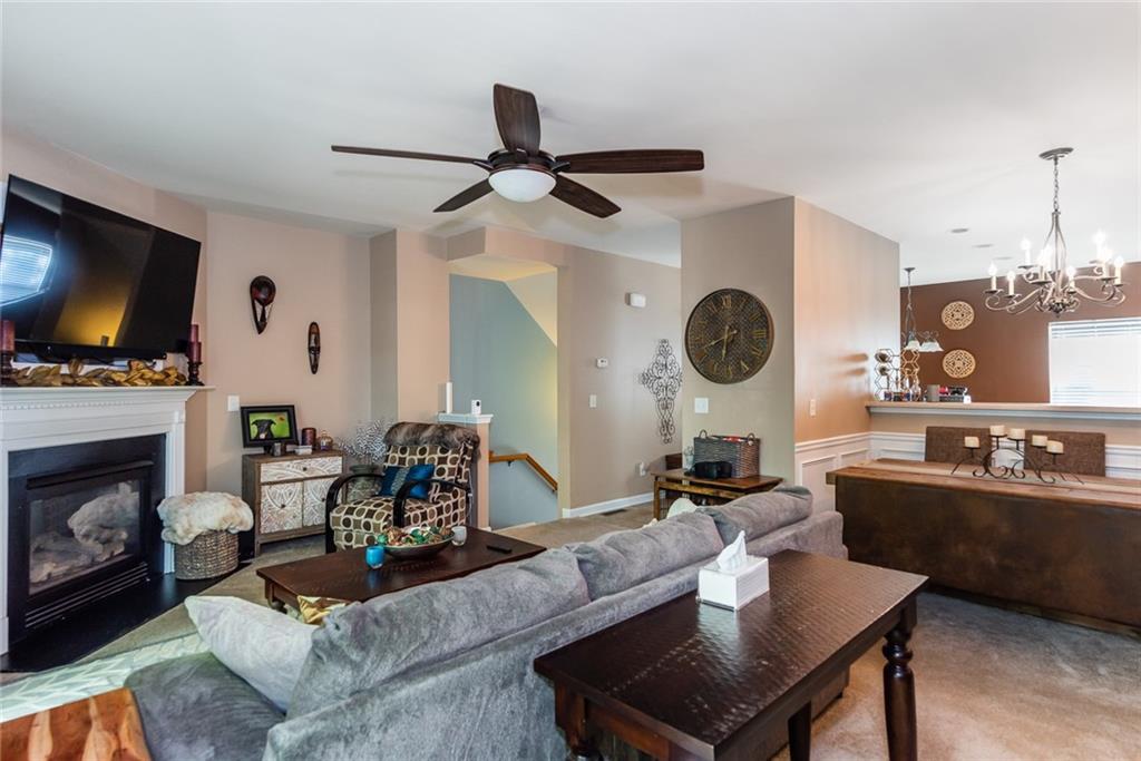2799 Keystone Avenue Lithonia, GA 30058 - Photo 15 of 41 a living room with furniture a fireplace a flat screen tv and kitchen view