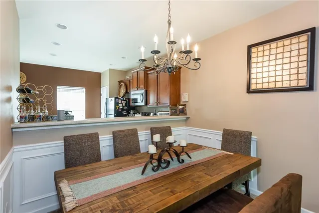 a view of a dining room with furniture a chandelier and wooden floor