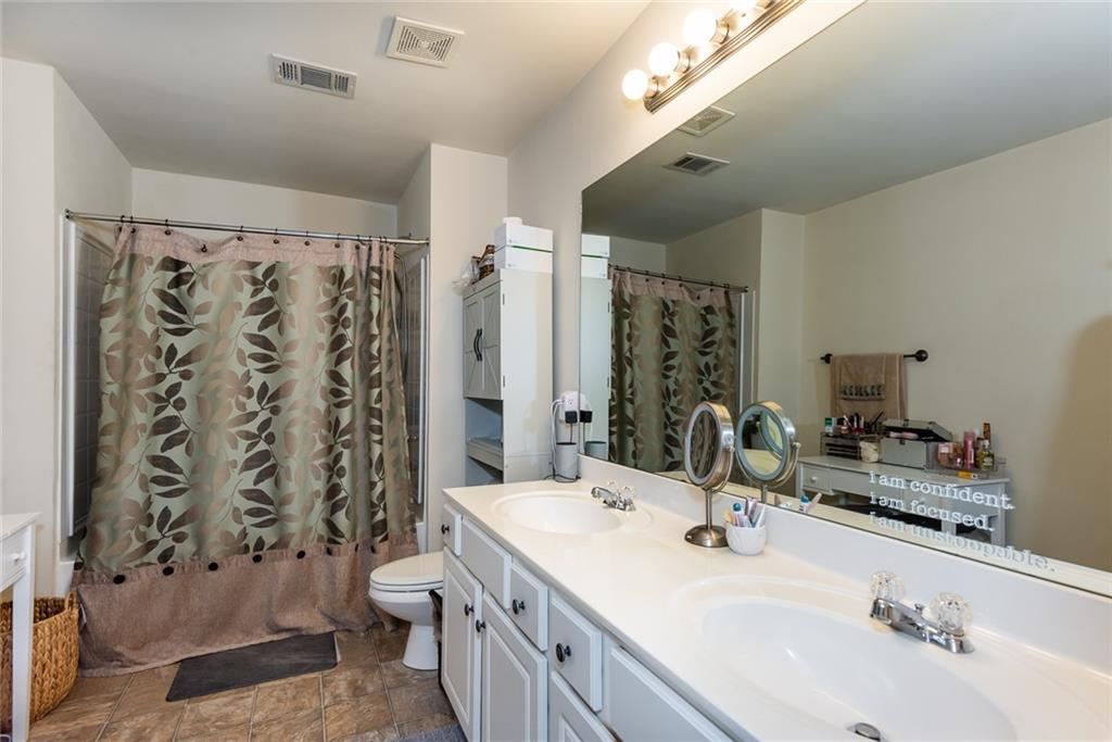 2799 Keystone Avenue Lithonia, GA 30058 - Photo 32 of 41 a bathroom with a double vanity sink toilet mirror and shower