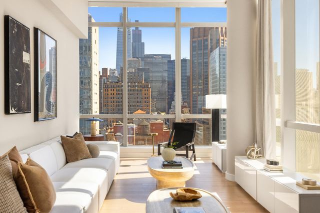 a living room with furniture and floor to ceiling windows