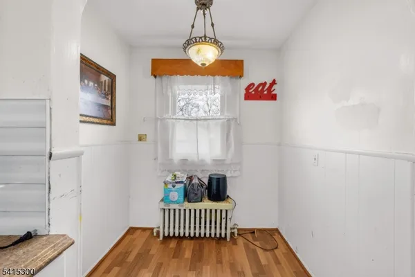 a view of a room with wooden floor and entryway