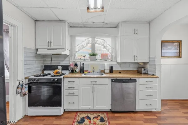 a kitchen with granite countertop white cabinets and white appliances