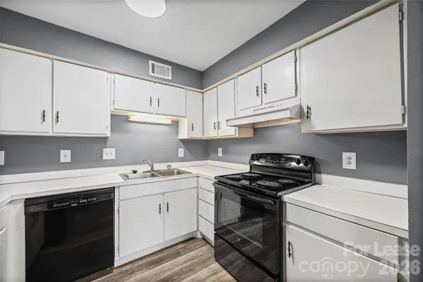 a kitchen with a sink a refrigerator and cabinets
