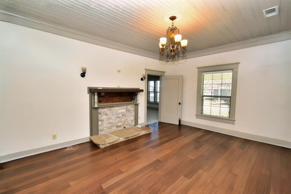 269 Holley Street Alba, TX 75410 - Photo 12 of 37 a view of an empty room with wooden floor fireplace and a window
