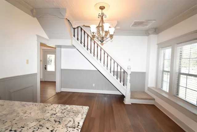 a view of a living room and kitchen with wooden floor