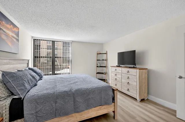 a view of a kitchen with refrigerator and wooden floor