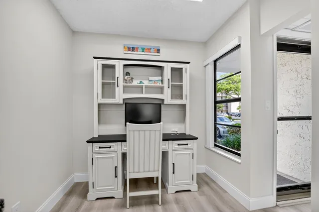 a patio with a table and chairs and potted plants