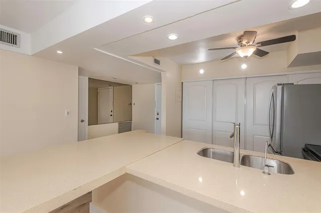 a view of a kitchen with a sink and wooden cabinets