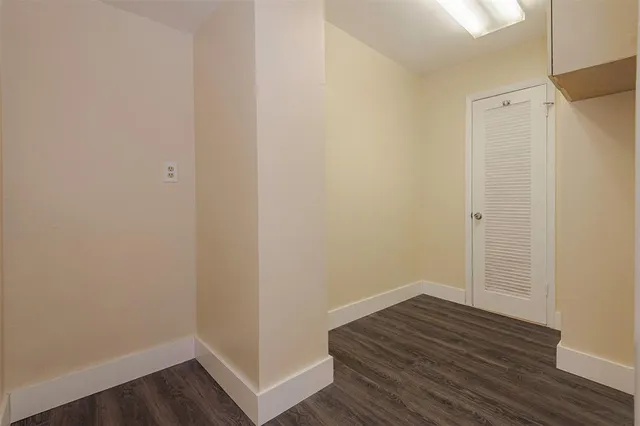 an empty room with wooden floor and window