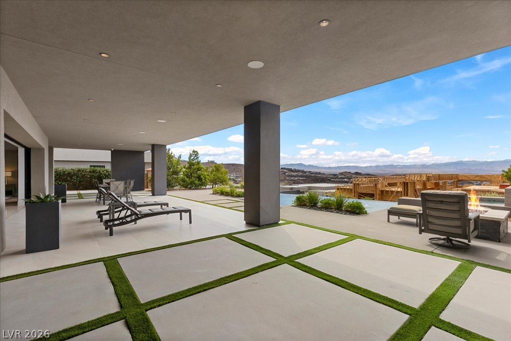 657 Ridgestone Rim Court Henderson, NV 89012 - Photo 90 of 97 Concrete pavers inset with turf lead to a covered patio framing mountain vistas.