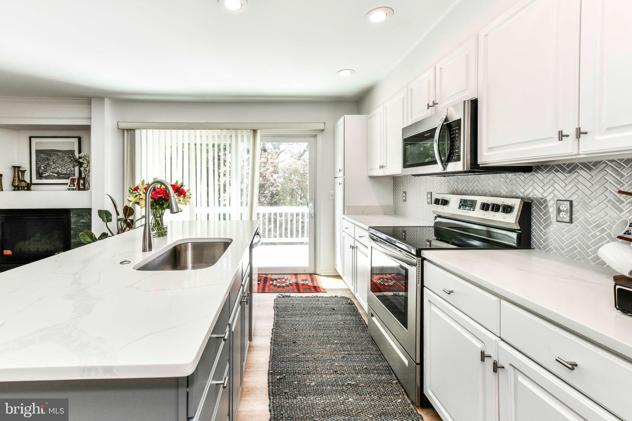 12066 Edgemere Circle Reston, VA 20190 - Photo 9 of 28 a kitchen with stainless steel appliances a white wooden cabinets and a stove top oven