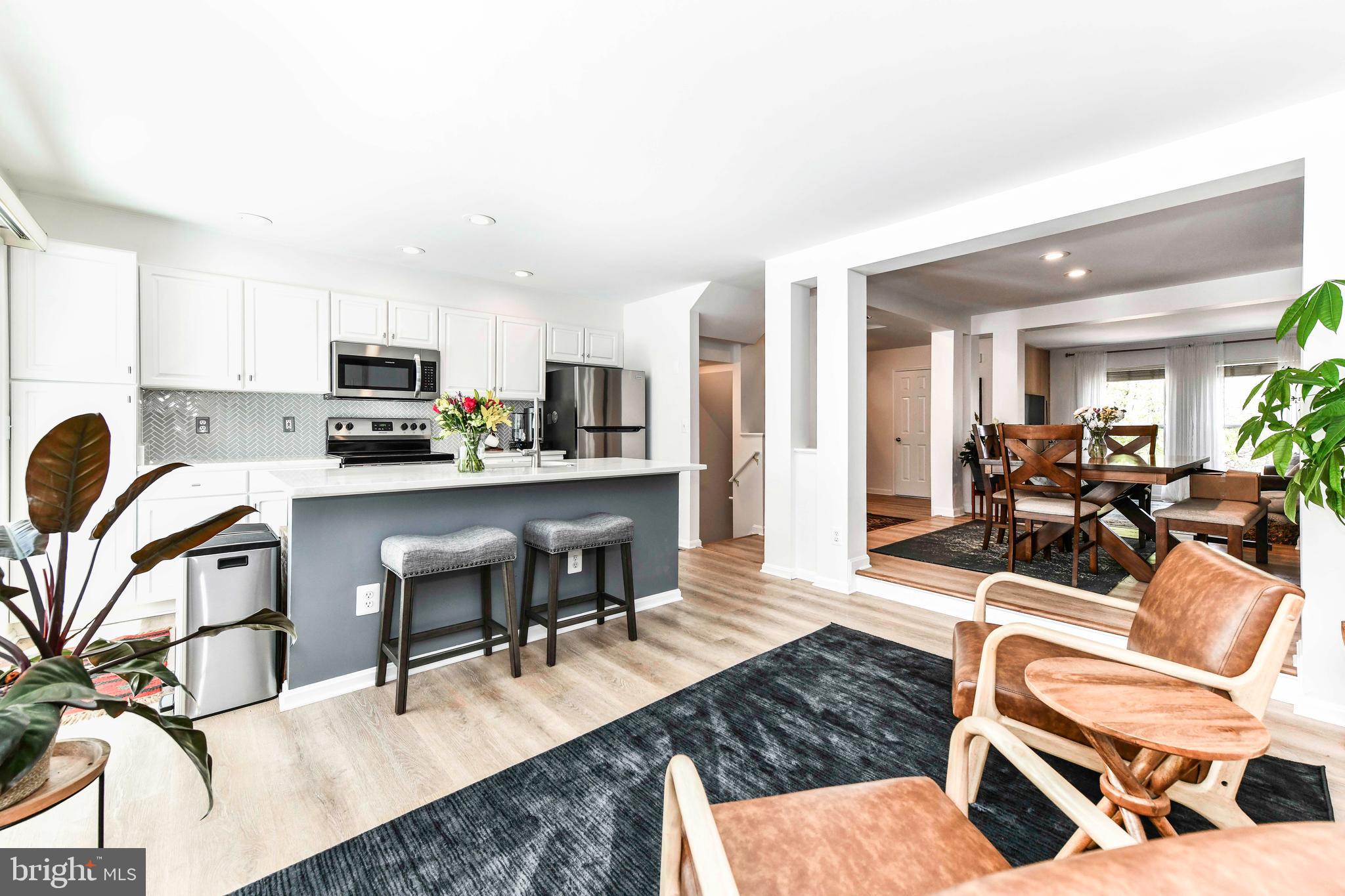 12066 Edgemere Circle Reston, VA 20190 - Photo 10 of 28 a living room with stainless steel appliances kitchen island furniture and a wooden floor