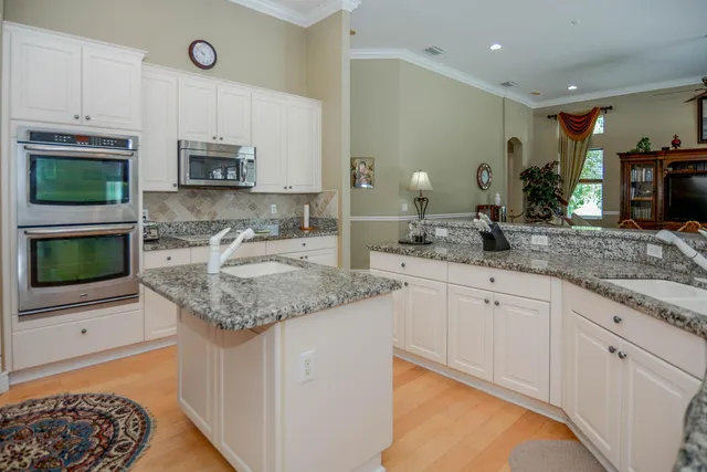 a kitchen with stainless steel appliances granite countertop a sink stove and microwave