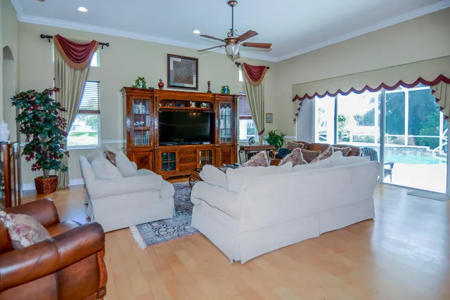 a living room with furniture a flat screen tv and a floor to ceiling window