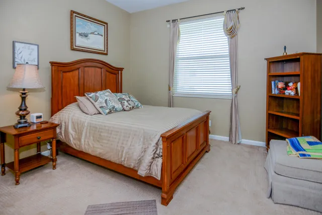 a bedroom with a bed and a lamp on the dresser