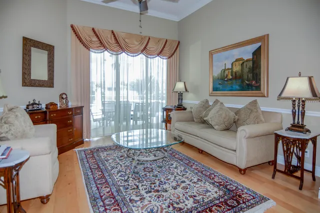 a kitchen with stainless steel appliances kitchen island granite countertop a stove a refrigerator a oven a dining table and chairs with wooden floor