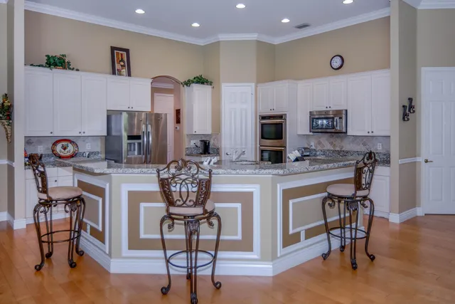 a kitchen with granite countertop a refrigerator and a stove top oven