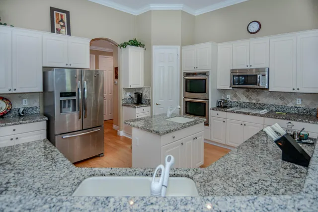 a kitchen with stainless steel appliances granite countertop a sink stove and microwave