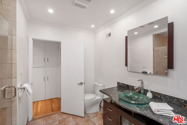 a bathroom with a granite countertop sink a toilet and mirror