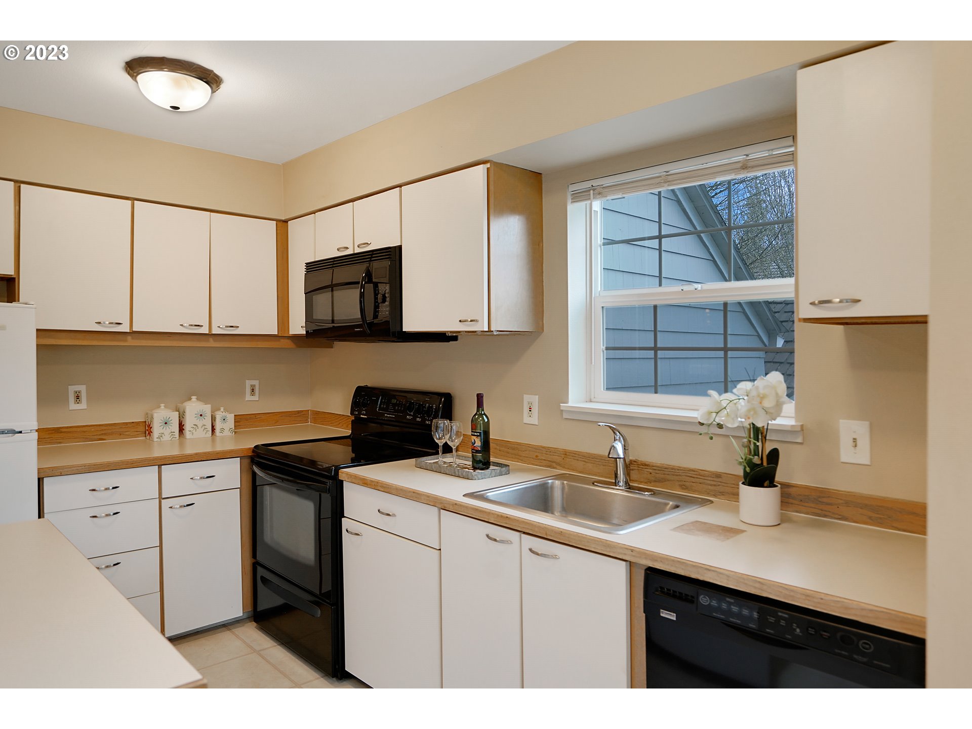 8415 Southwest Curry Drive, Unit A Wilsonville, OR 97070 - Photo 15 of 36 a kitchen with stainless steel appliances a sink a stove a microwave a sink and cabinets