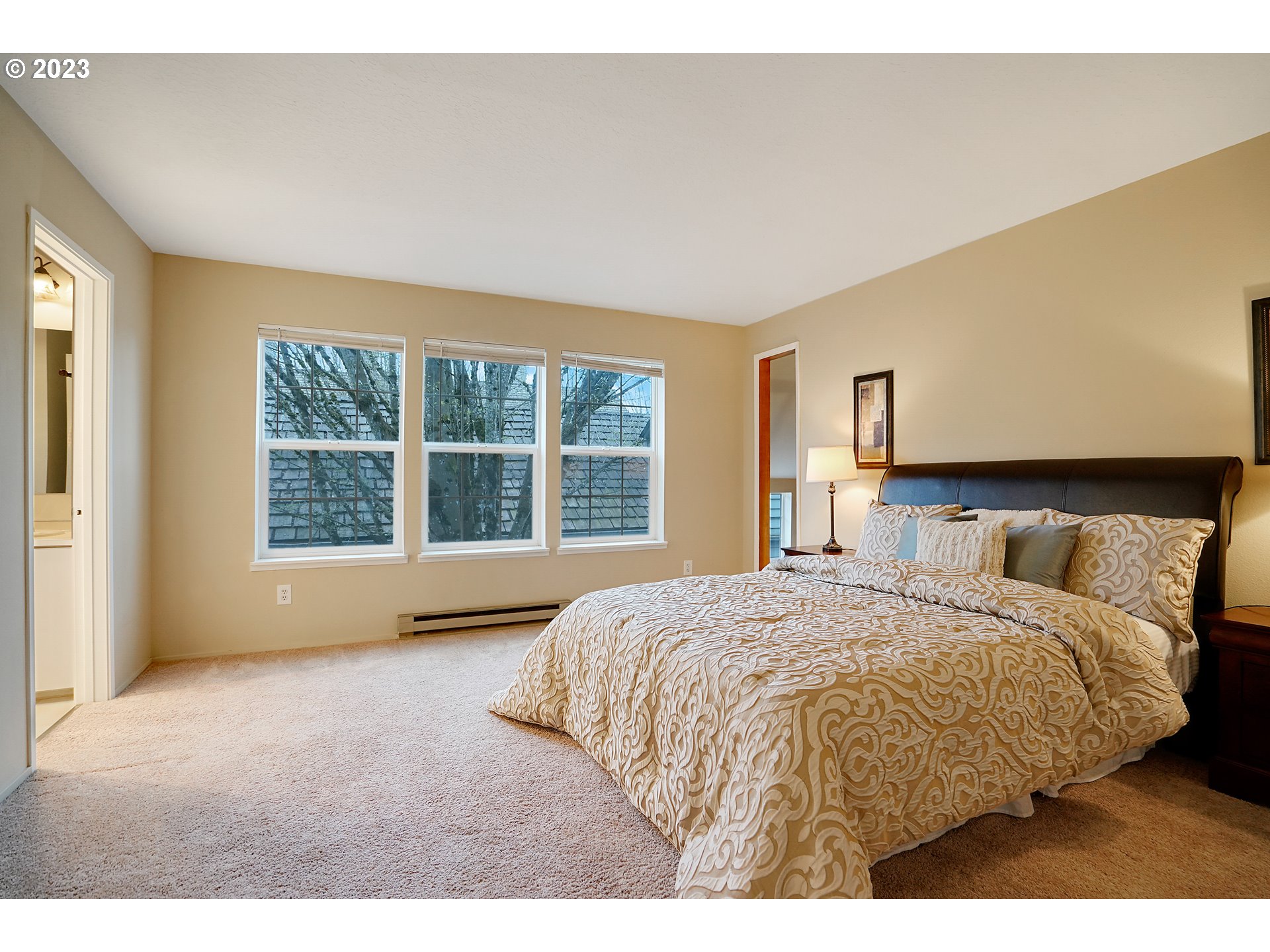8415 Southwest Curry Drive, Unit A Wilsonville, OR 97070 - Photo 22 of 36 a bedroom with a large bed and a large window