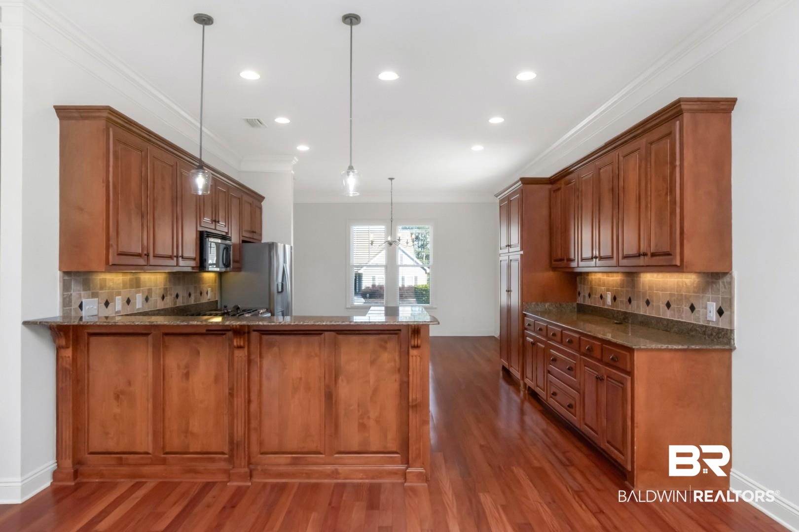 30585 Pine Court Daphne, AL 36527 - Photo 7 of 49 Kitchen featuring brown cabinetry, tasteful backsplash, a peninsula, pendant lighting, and recessed lighting