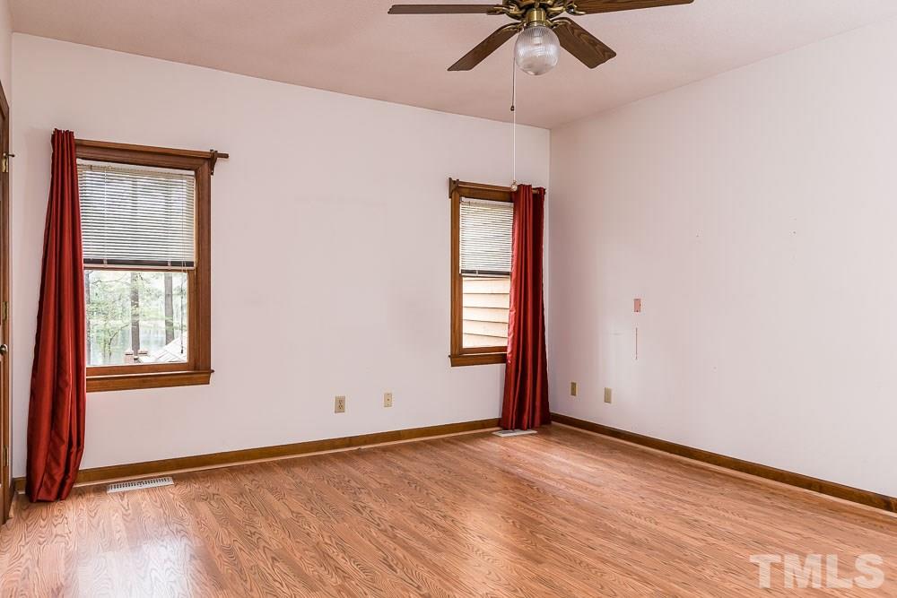 7643 Trowbridge Court Raleigh, NC 27613 - Photo 13 of 26 an empty room with a window and ceiling fan