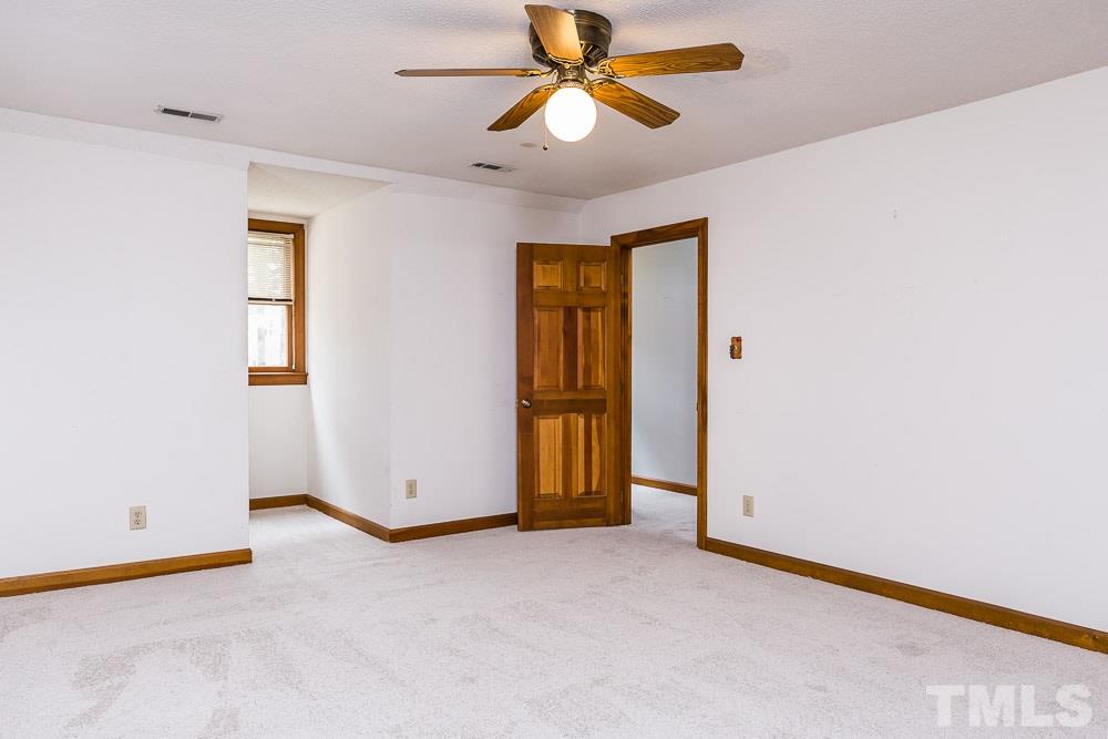 7643 Trowbridge Court Raleigh, NC 27613 - Photo 18 of 26 an empty room with closet and a chandelier fan