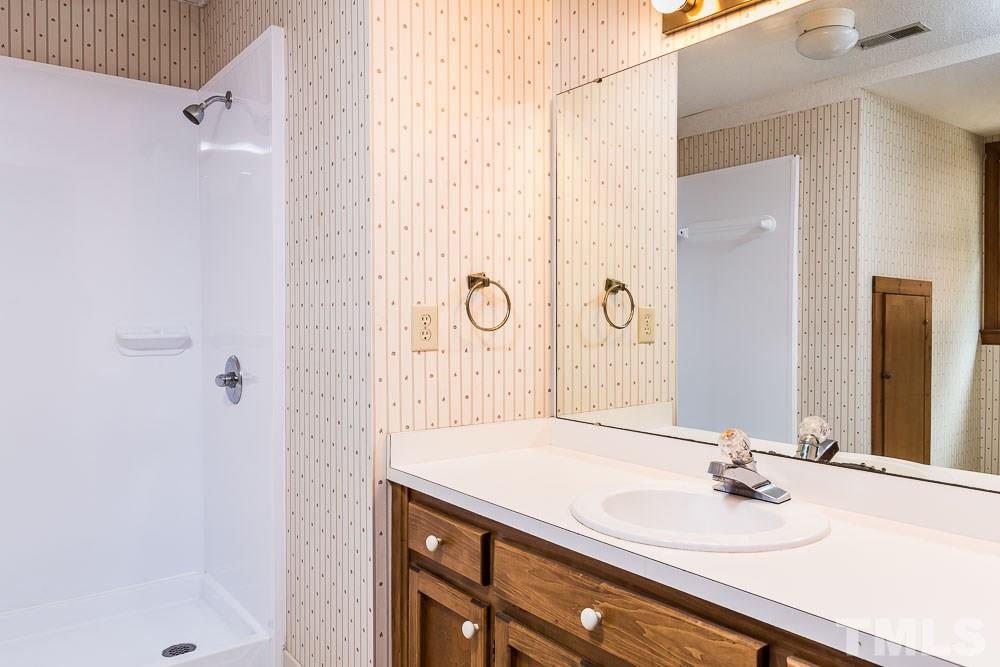 7643 Trowbridge Court Raleigh, NC 27613 - Photo 19 of 26 a bathroom with a sink and a mirror