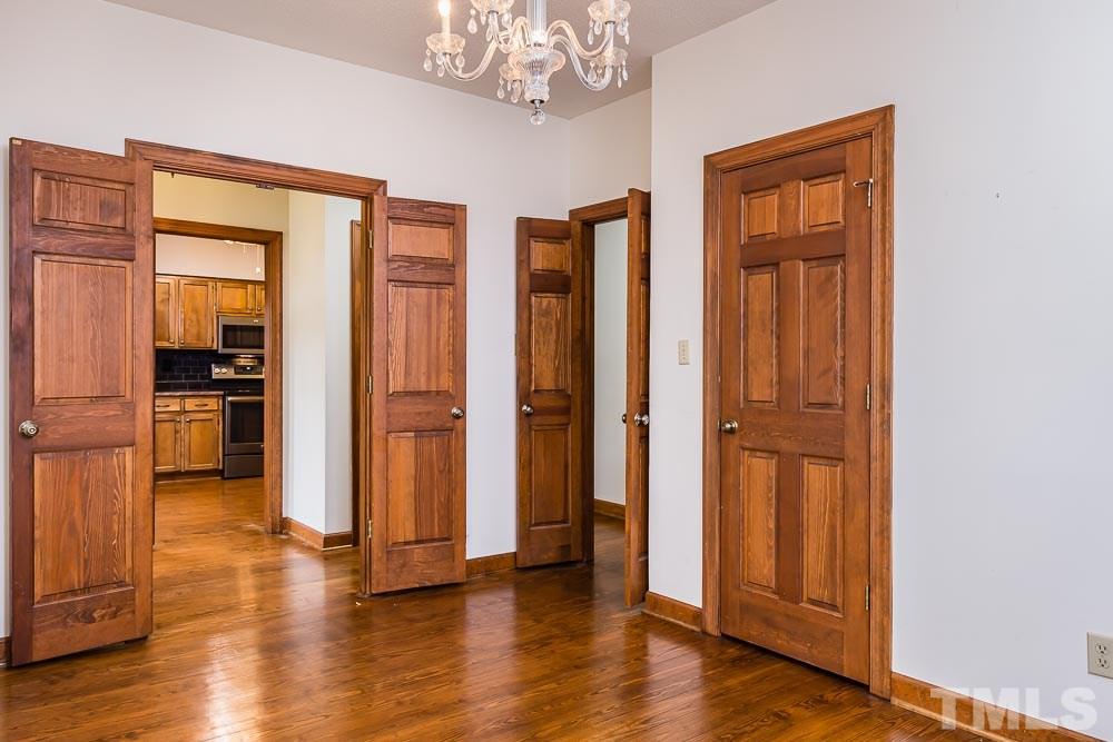 7643 Trowbridge Court Raleigh, NC 27613 - Photo 7 of 26 a view of a hallway with wooden floor and staircase