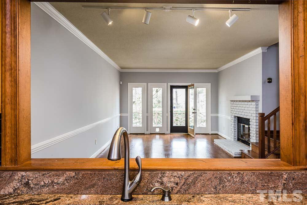 7643 Trowbridge Court Raleigh, NC 27613 - Photo 8 of 26 a view of an empty room with wooden floor and a fireplace