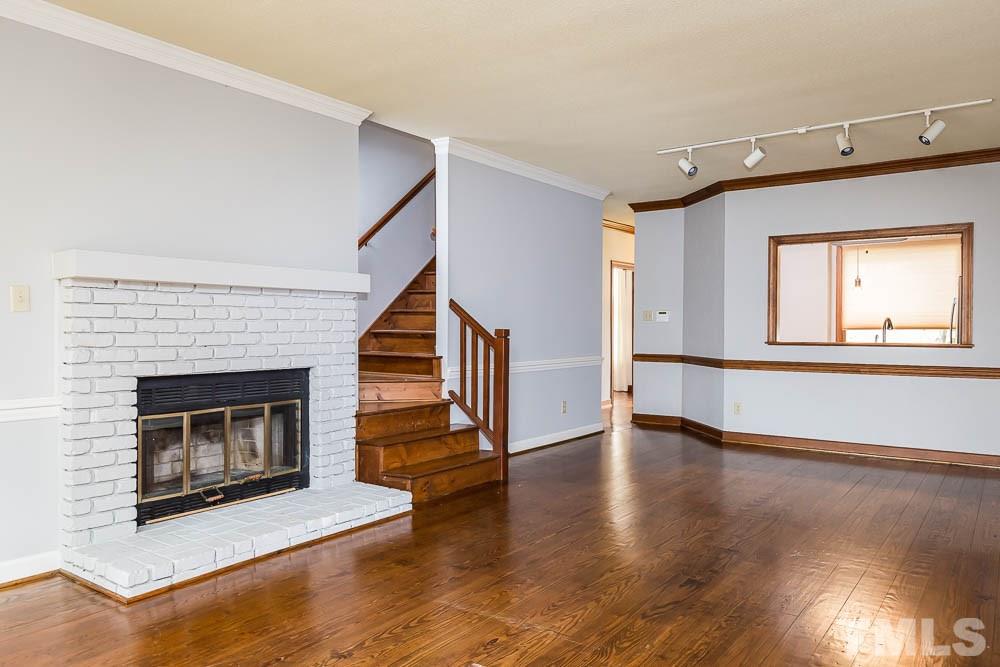7643 Trowbridge Court Raleigh, NC 27613 - Photo 9 of 26 a living room with wooden floors and a fireplace