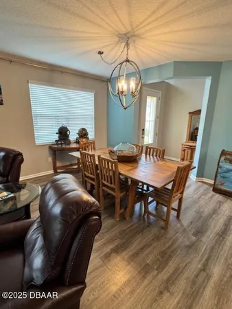 a view of a dining room with furniture wooden floor and chandelier