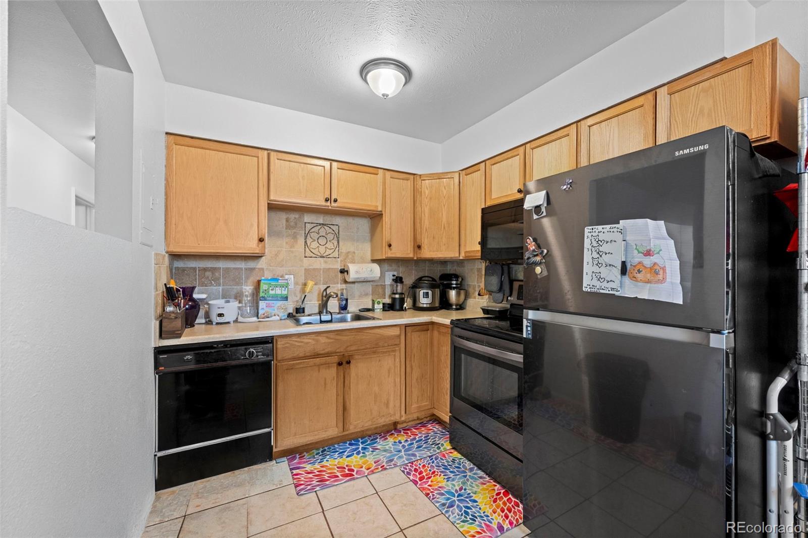 9240 West 49th Avenue, Unit 306 Wheat Ridge, CO 80033 - Photo 3 of 14 a kitchen with stainless steel appliances a stove sink and refrigerator