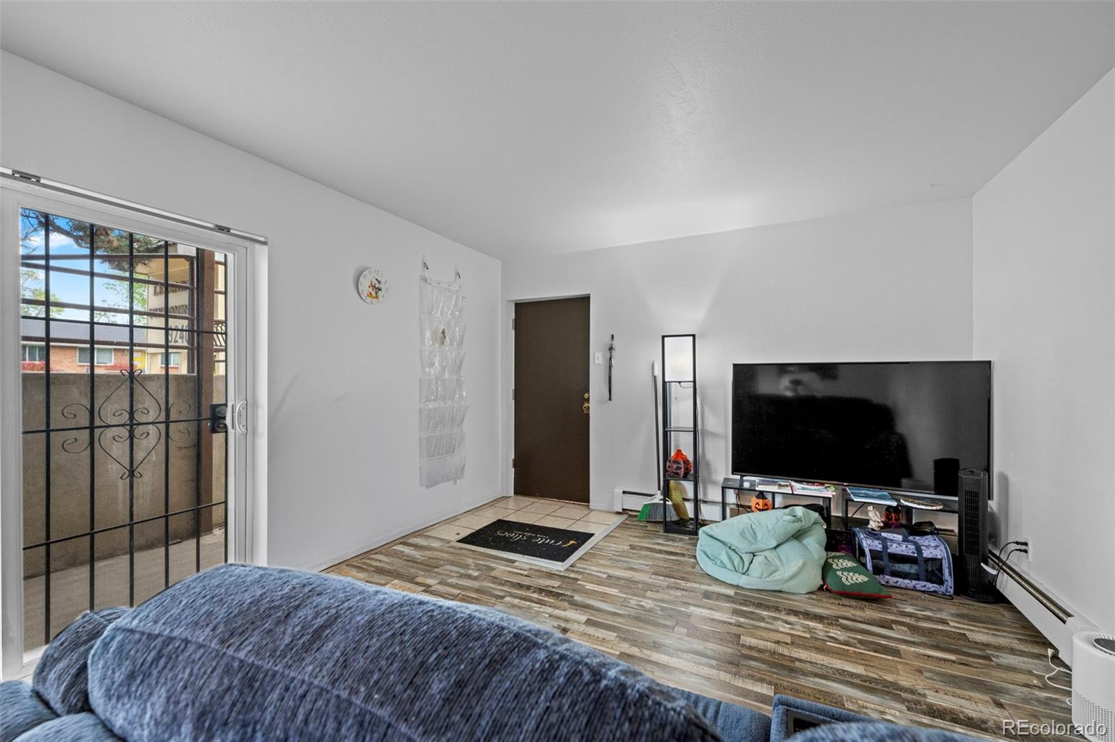 9240 West 49th Avenue, Unit 306 Wheat Ridge, CO 80033 - Photo 4 of 14 a bedroom with a bed and a flat screen tv