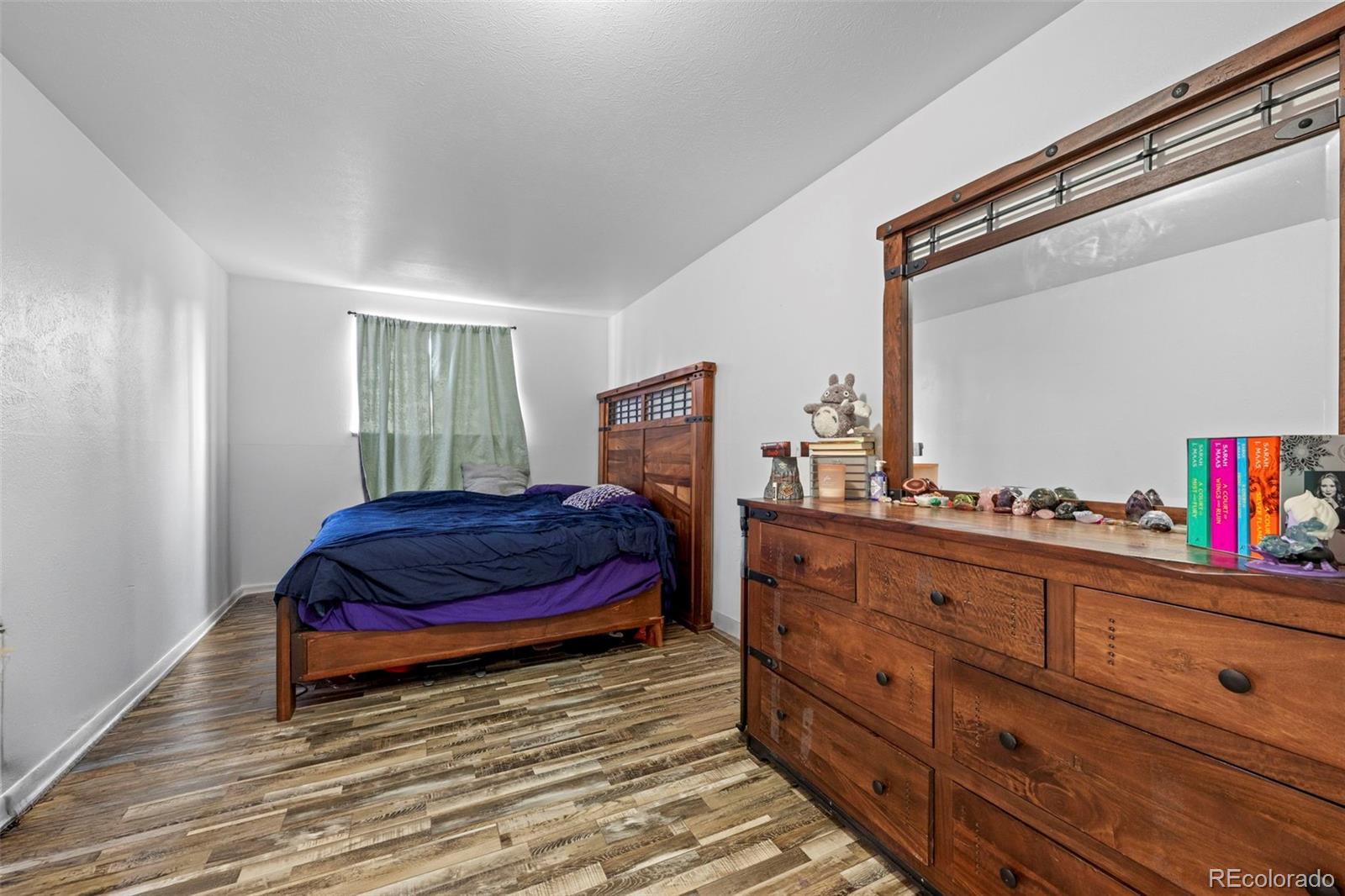 9240 West 49th Avenue, Unit 306 Wheat Ridge, CO 80033 - Photo 5 of 14 a bedroom with a bed and a dresser