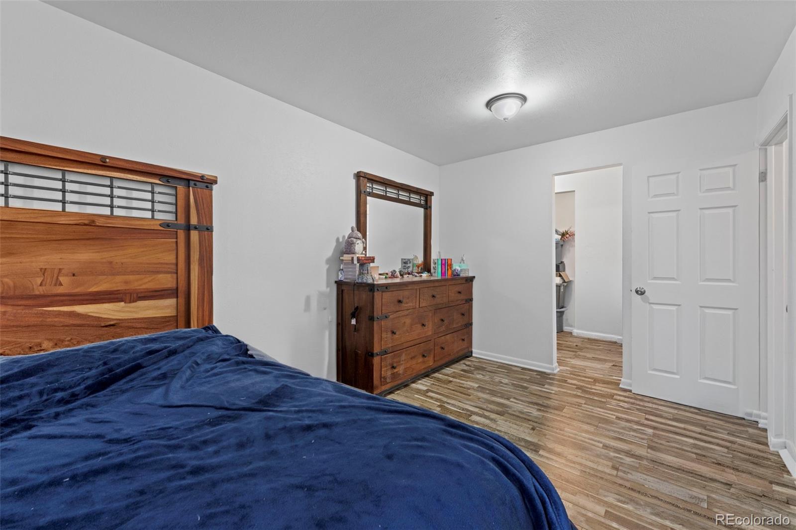 9240 West 49th Avenue, Unit 306 Wheat Ridge, CO 80033 - Photo 6 of 14 a bedroom with a bed and a dresser