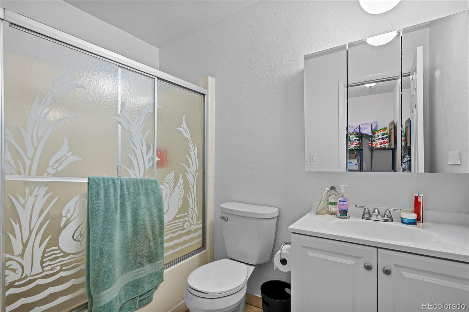 9240 West 49th Avenue, Unit 306 Wheat Ridge, CO 80033 - Photo 7 of 14 a bathroom with a sink a toilet and shower