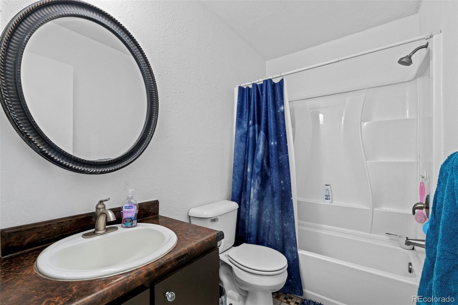 9240 West 49th Avenue, Unit 306 Wheat Ridge, CO 80033 - Photo 9 of 14 a bathroom with a sink a toilet and a mirror
